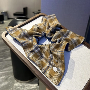 Détail d'un chouchou à carreaux avec strass, bouton vintage et pendentif fleur en perle