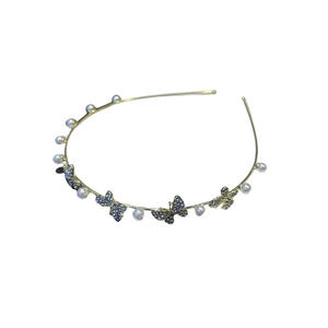 Elegant gold headband with white pearls and rhinestone butterflies on white background