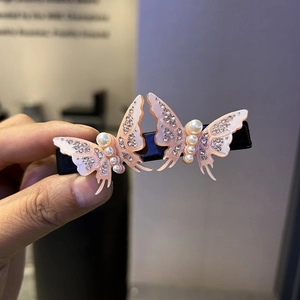 Elegant butterfly hair clip with crystal rhinestones and pearls on black spring base