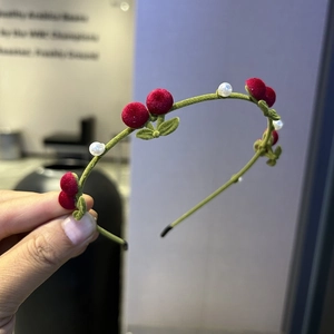 Détail d'un serre-tête en velours avec cerises floquées rouges, feuilles et perles blanches