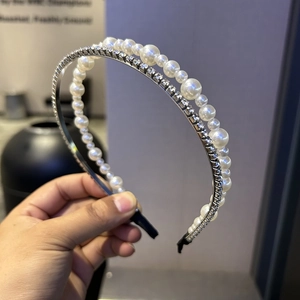Detailed view of layered headband set with white faux pearls and silver rhinestones