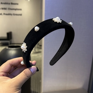 Detail of black velvet headband with white pearls and sparkling rhinestones flowers