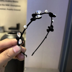 Détail de serre-tête en velours avec perles blanches et fleurs en cristal brillant