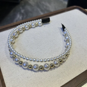 Close-up of elegant double-layered pearl and gold bead headband with comfortable fabric tips