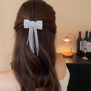 Elegant silver bow hair clip with sparkling rhinestone tassels worn on back of head