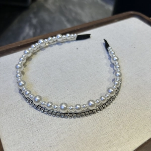 Detail of a double-layered headband with elegant white pearls and sparkling rhinestones