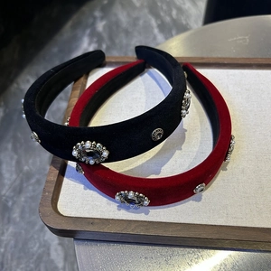 Close-up of luxury velvet headbands with baroque rhinestones and pearls on a tray
