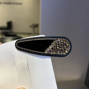 Elegant black velvet hair clip with champagne gold rhinestones in a teardrop design
