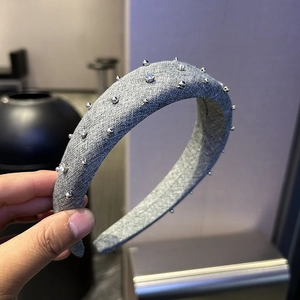 Elegant grey padded headband featuring sparkling rhinestones and silver stud embellishments