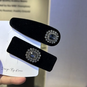 Close-up of black velvet hair clips with vintage rhinestone and grey crystal detail