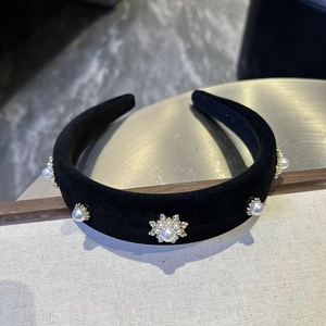 Close-up of black velvet headband with floral faux pearl and rhinestone embellishments