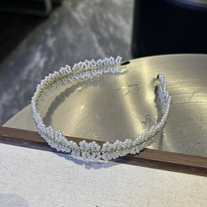 Détail d'un serre-tête en perles avec cristaux étincelants et design ondulé élégant