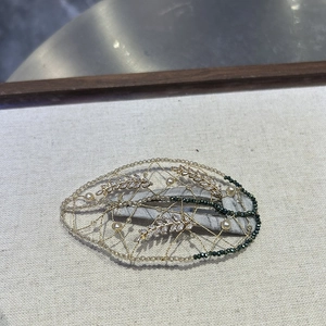 Detail of handmade gold woven hair clip with marquise rhinestones and white pearls