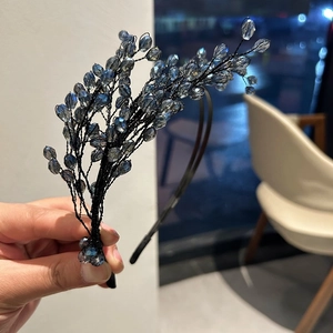 Dettaglio di perle di cristallo blu intrecciate in un cerchietto da sposa stile vintage