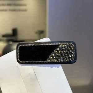 Close-up of a velvet hair clip with rhinestone trim and grey crystal geometric decoration