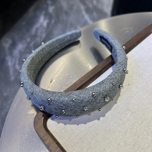 Close-up of grey fabric headband with silver studs and rhinestones detail