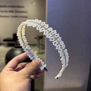 Détail d'un serre-tête avec perles artificielles tressées et strass étincelants