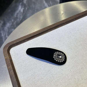 Close-up of black velvet BB hair clip with vintage rhinestone and grey gemstone