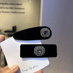 Detail of luxury black velvet hair clips featuring emerald cut crystals and small diamonds
