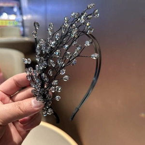 Dettaglio di un cerchietto intrecciato a mano con cristalli grigi per acconciature da sposa