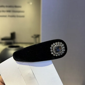 Macro shot of black velvet headband with elegant crystal rhinestone flower embellishment