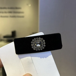 Macro shot of black velvet hair clip featuring a vintage crystal gemstone and silver setting