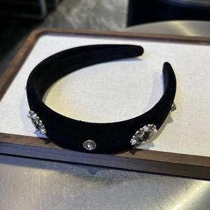 Detailed view of luxury black velvet headband with vintage pearls and crystals on display