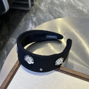 Detail of handmade wide headband with silver sequins and rhinestones on black fabric