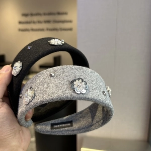 Detail of handmade sequin flowers and rhinestones on thick wool headbands in black and grey