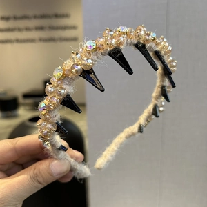 Detail eines beigen Plüsch-Haarreifens mit Champagner-Kristallperlen und schwarzem Innenzahn