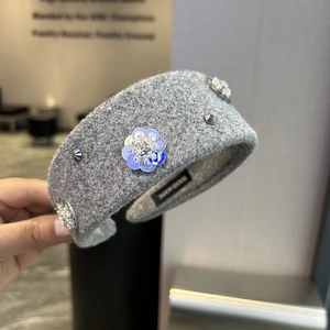 Detail of grey woolen headband with blue sequin flowers, rhinestones and metal studs