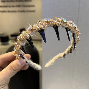 Detail eines handgestrickten beigen Haarreifs mit Champagner-Kristallen und Innenzähnen
