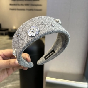 Macro detail of handmade grey wool headband with silver sequins and sparkling rhinestones