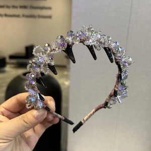 Detail of beaded crystal floral headband featuring champagne fabric and black hair comb