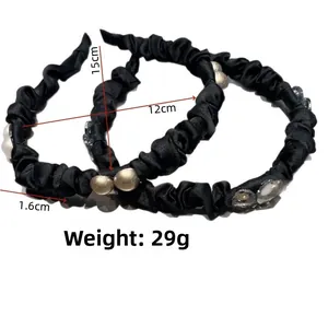 Detail view of black pleated headbands with elegant pearls and 15cm x 12cm size dimensions