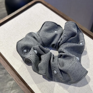Gray fabric floral scrunchie with elegant pearl accents and textured crinkle design