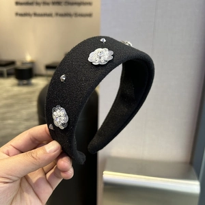 Macro detail of black padded headband with sequin flowers and silver rhinestone accents