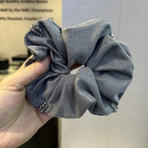 Close-up of dark grey metallic fabric scrunchie with sparkling beads for women