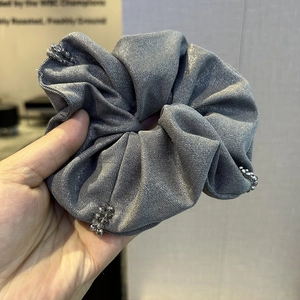 Close-up of silver-grey scrunchie with metallic sheen fabric and elegant silver beads