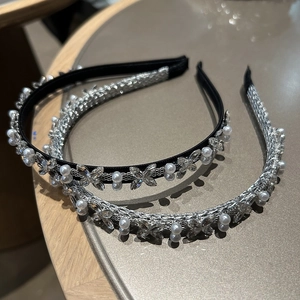Nahaufnahme von Perlen- und Strass-Schmetterlings-Haarbändern in Schwarz und Silber