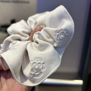 Elegant off-white fabric scrunchie with 3D embossed camellia pattern and pearl accents