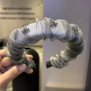 Detailed macro view of silver mesh headband with handmade beads and pleated texture