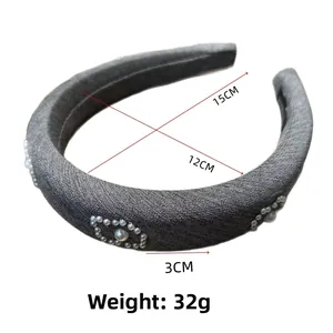 Detail of grey fabric headband with white pearl floral patterns and size specifications