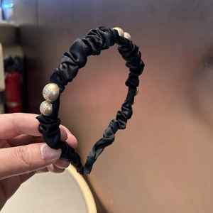 Elegant black pleated satin headband featuring gold bead accents for high crown volume styling