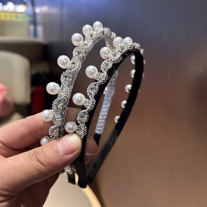 Detail von Haarreifen mit Diamanten und Perlen auf Silbermetall und schwarzem Stoff