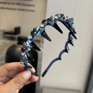 Détail d'un serre-tête en cristal bleu foncé avec pinces à tresser et strass brillants