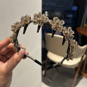Detail of floral crystal headband showing champagne beads and black plastic teeth grip