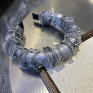 Detail of grey pleated tulle headband with elegant hand-stitched crystal beads