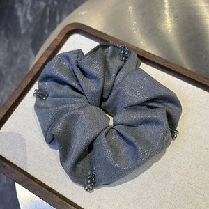 Close-up of grey shiny metallic scrunchie with translucent bead clusters for hair