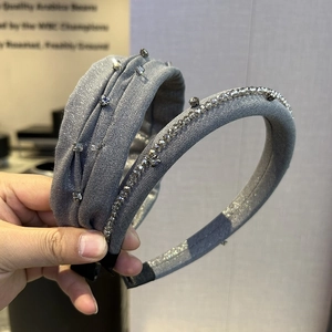 Detail of grey pleated headband with rhinestones and thick satin hair hoop for women